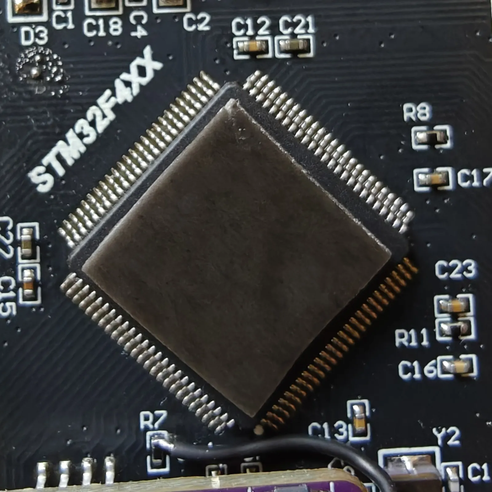 A square of foam tape cut to the STM32's package and stuck to its lid
